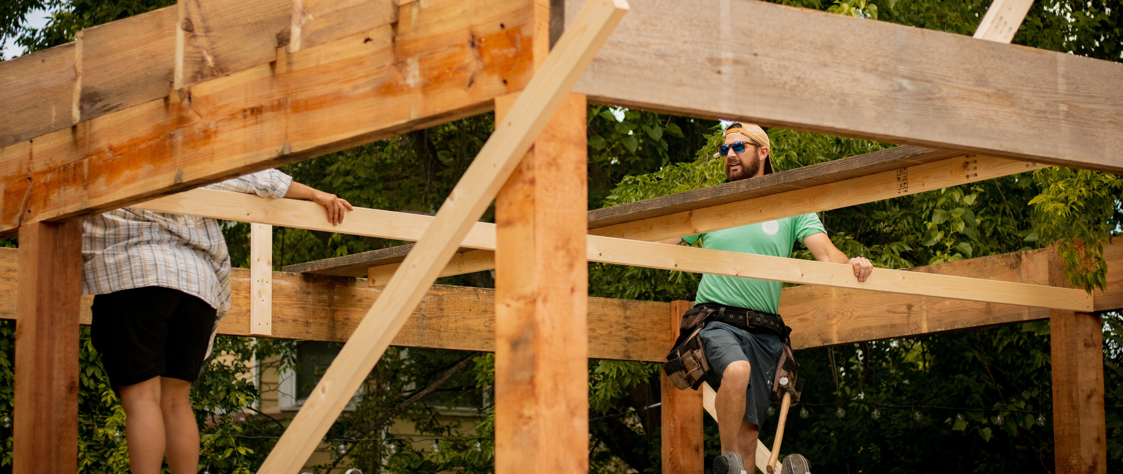 Zwei Männer bauen ein Holzhaus, dank der Bauherrenhaftpflichtversicherung