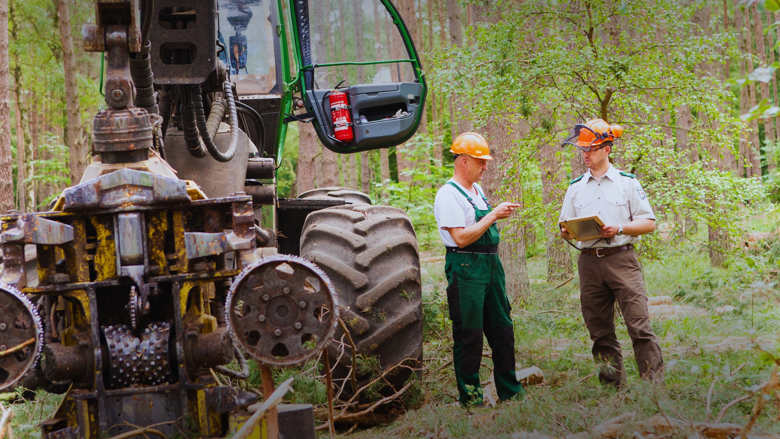 Forstbeamter der bei der Arbeit im Wald abgesichert ist mit seinem Kollegen und Forstmitarbeiter, geschützt von der Diensthaftpflichtversicherung des BDF Sozialwerk