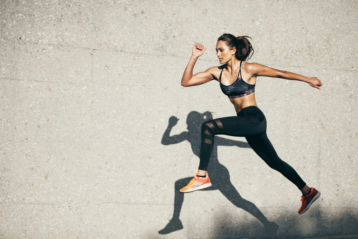 Eine sprintende Frau in Sportkleidung