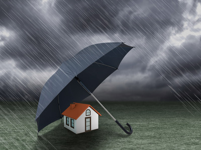 Ein Haus das von einem Regenschirm geschützt wird, es Regnet | Elementarversicherung