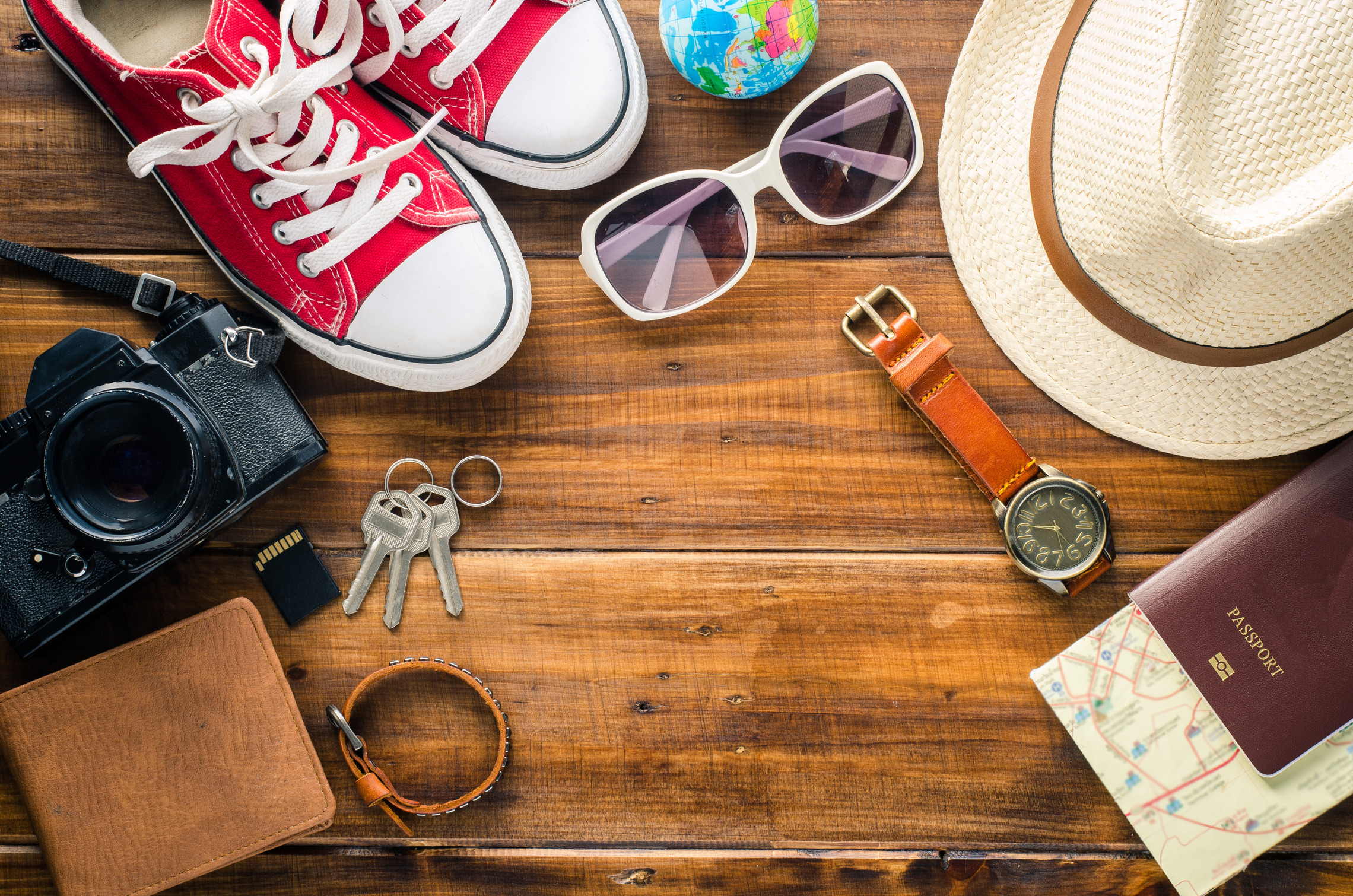 Sommer, Sonne, Strand und Meer Inhalt eines Koffers auf einem Holzboden ausgelehrt | Reiseversicherung