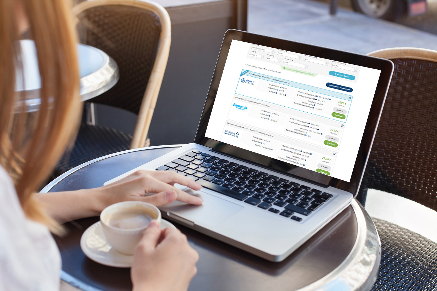 Ein eingeschalteter Laptop auf einen kleinen Tisch, es bedient ihn eine Person und genießt einen Kaffe. Der Laptop zeigt den Online Rechner